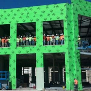 A building with green walls and people on the roof.