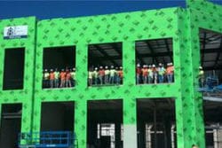 A building with green walls and people on the balcony.