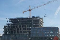 A crane is in front of a building under construction.